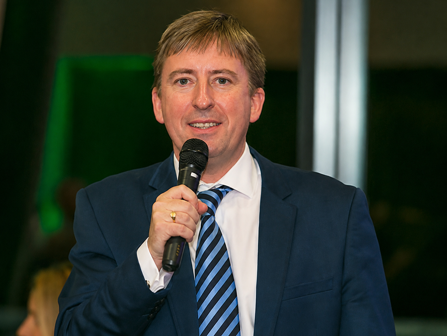 Nick Johnson hosting an event with a microphone in hand